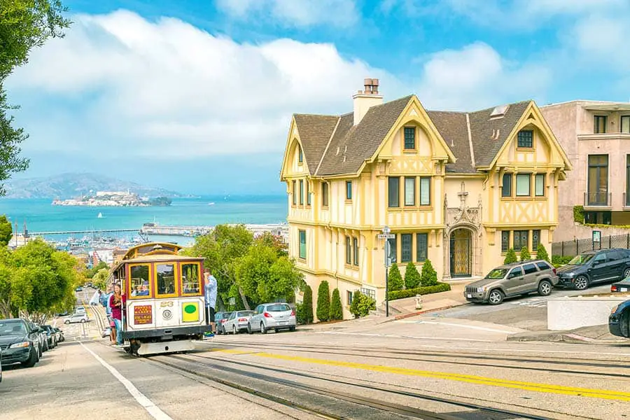 Passengers riding cable car up steep street