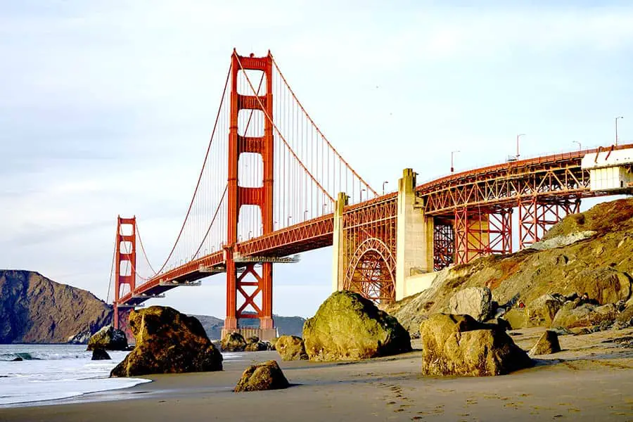 Beach view of iconic red towers and bridge