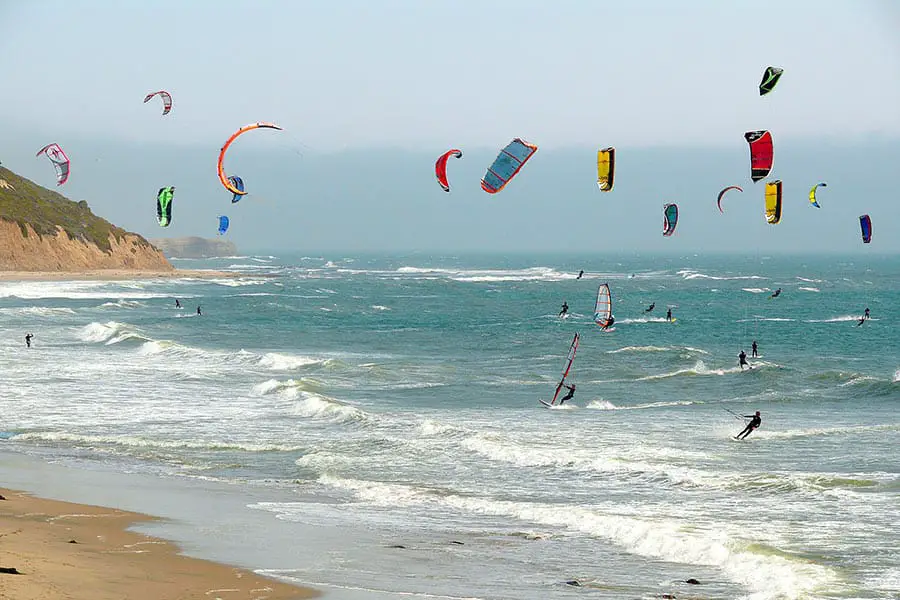 View of Pacific Ocean with colorful windsurfers