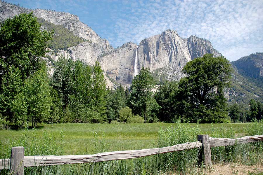 Grassy meadow and rugged mountains at Yosemite National Park