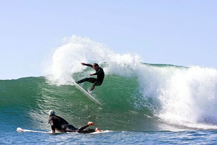 Two surfers riding wave at Santa Cruz, California