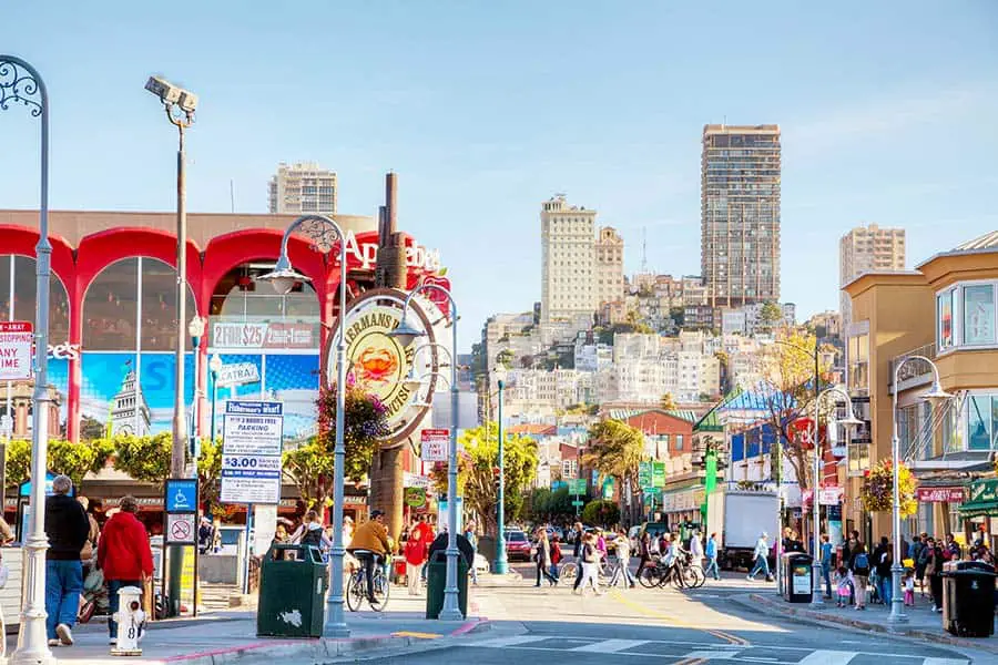 Tourists at Fisherman's Wharf, city skyscrapers in background