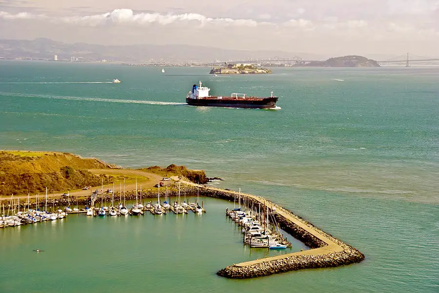 Boats at dock, tanker ship navigates the bay