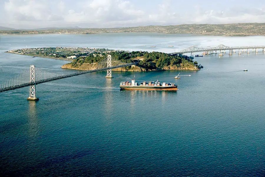 Cargo ship passing under Bay Bridge in San Francisco Bay