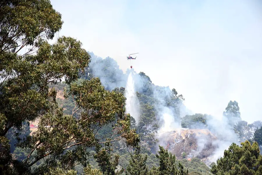 Helicopter dropping water on fire at Grizzly Peak