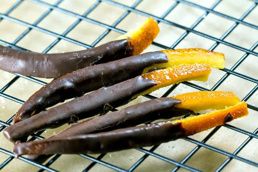 Candied orange peel dipped in chocolate on wire rack