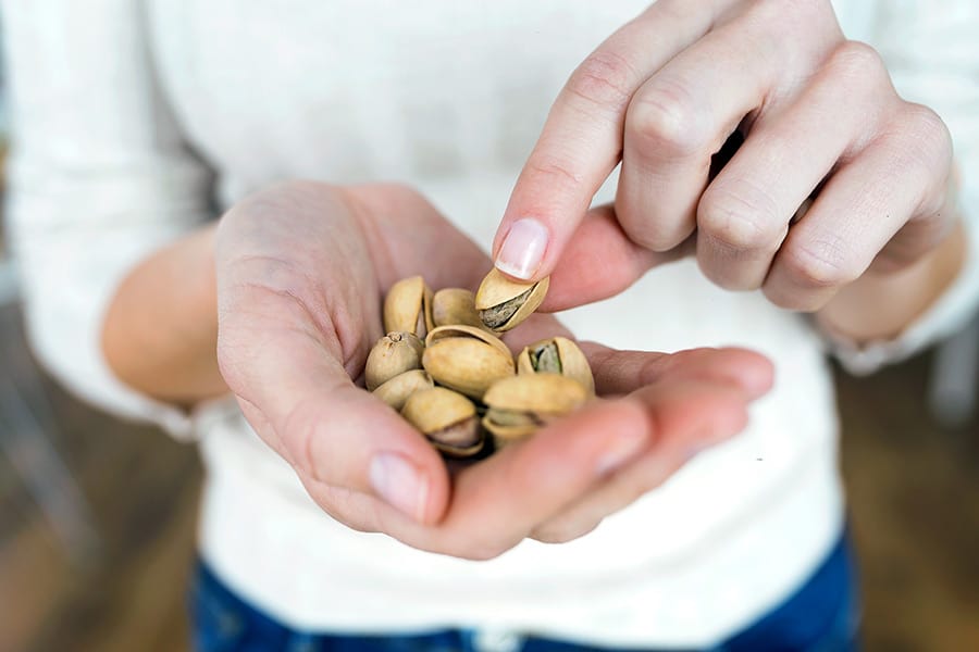 Woman with a handful of pistachios
